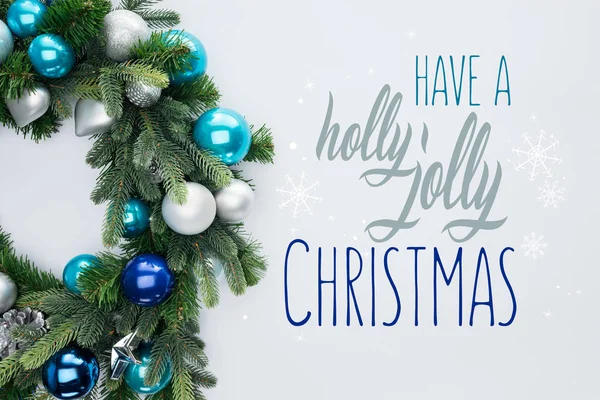 装饰节日花圈的最高视图与蓝色和银色的圣诞玩具隔离在白色与 有一个冬青快乐的圣诞节 的灵感 — 图库照片
