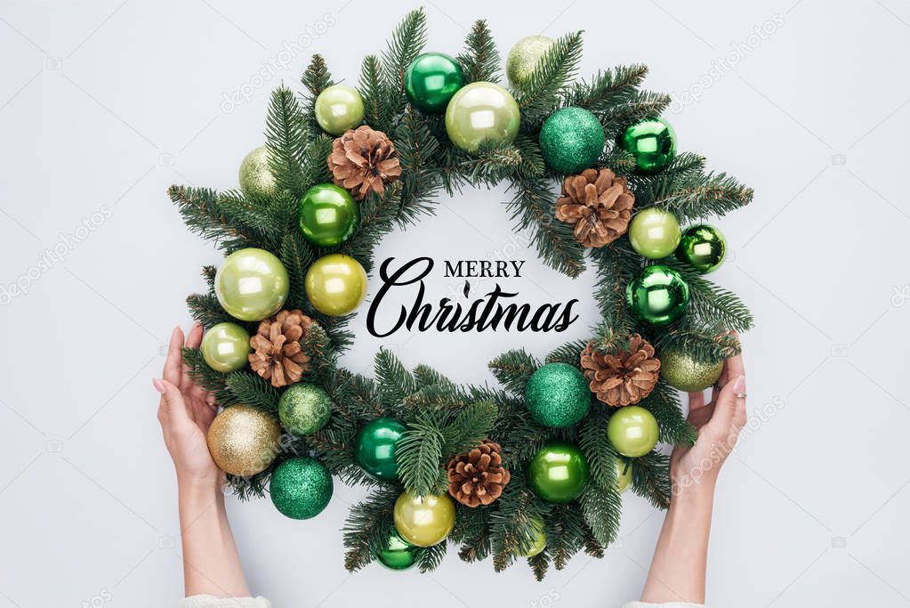 cropped shot of woman holding christmas wreath  with 