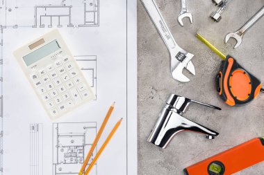 çeşitli araçlar ve hesap makinesi ile plan beton yüzeyinde binanın üstten görünüm