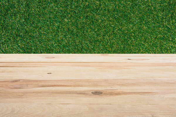 template of beige wooden floor with green grass on background