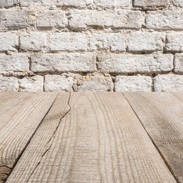 surface of beige wooden planks with with brick wall on background