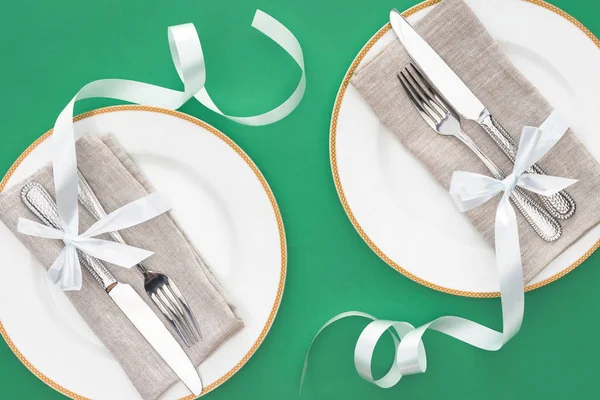 Flat Lay Forks Knives Wrapped Festive Ribbons Plates Isolated Green — Free Stock Photo