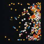 Vue élevée de pile coloré diverses pilules isolées sur noir