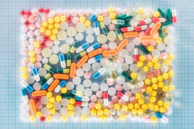 flat lay with rectangle made of various colorful pills on blue checkered surface clipart