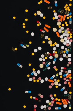 top view of pile colorful various pills isolated on black  clipart