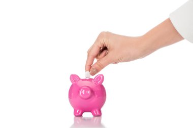 partial view of woman putting pill into pink piggy bank isolated on white clipart