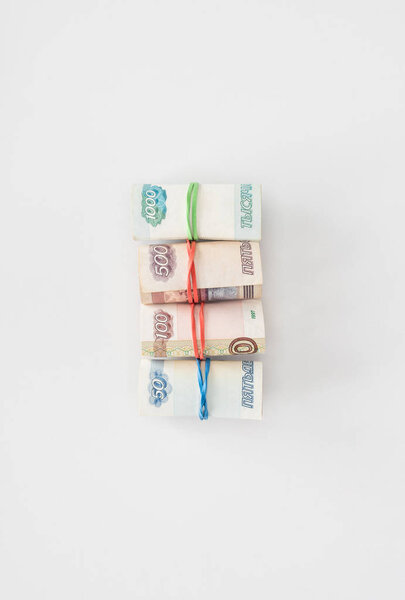 flat lay with arranged various russian rolled banknotes placed in row on white surface 