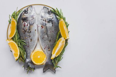 view from above o fish decorated by rosemary and lemon on plate clipart