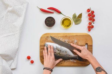 dövmeli kadın kesme balık bıçak, maddeler tablosundaki yakınındaki ahşap tahta üzerinde kırpılmış görüntü