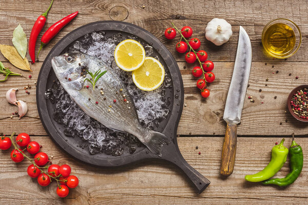 view from above of tray with uncooked fish surrounded by ingredients on table