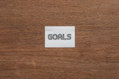 top view of 'goals' lettering on card with wooden background clipart