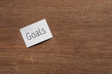 top view of 'goals' lettering on card with wooden background and copy space clipart