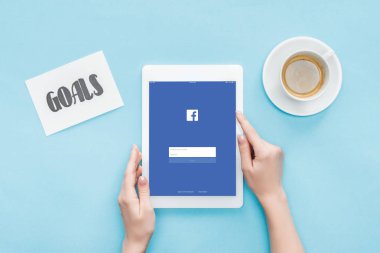 Erkek gol kartı ve kahve mavi arka plan üzerinde yazı ile facebook app üstünde perde, dijital tablet kullanarak kırpılmış görünümünü