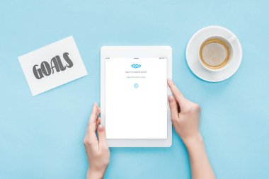 Kırpılan görünümünü erkek dijital tablet ekranında, skype uygulaması ile gol kartı ve kahve mavi zemin üzerine yazı kullanma
