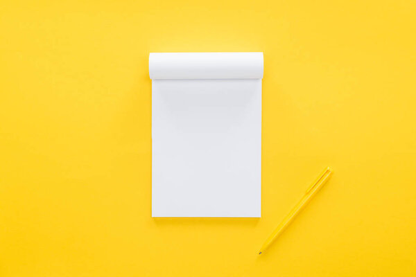 top view of blank notebook on yellow background