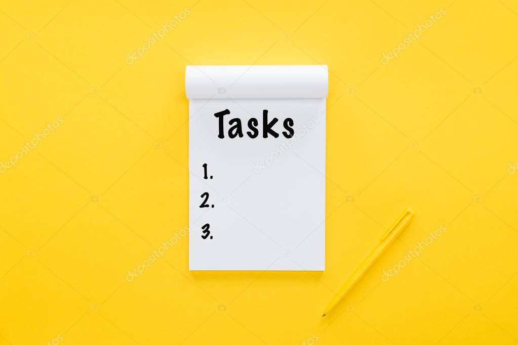 top view of notebook with tasks list on yellow