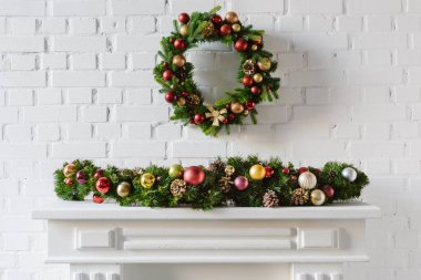 neşeli Noel çelenk şömine şömine ile beyaz tuğla duvar üzerine
