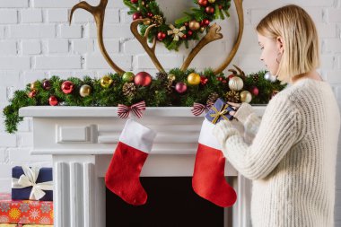 Genç kadın Hediyelik Noel çorap şömine, koyarak