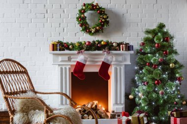 oturma odasında şömine, sallanan sandalye ile dekore edilmiş Noel ağacı