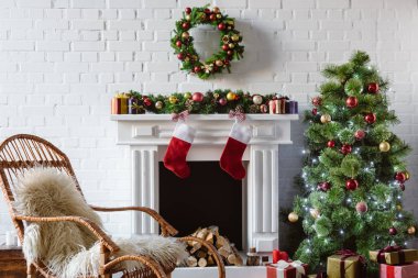 oturma odasında şömine, sallanan sandalye ile dekore edilmiş Noel ağacı