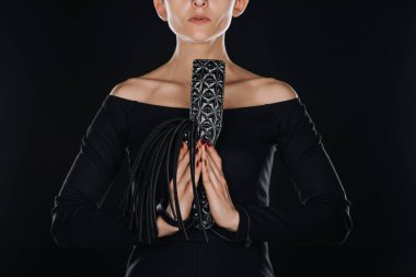 kadının siyah deri kırbaç kamçı tutan ve spanking kürek eller izole dua ile kısmi görünümü