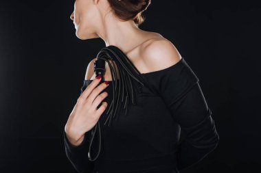 Kırpılan görünümünü siyah izole deri kırbaç kamçı tutan kadın