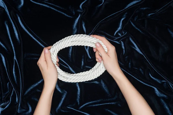 裁剪视图的女性手拿着绳子在天鹅绒背景 — 免费的图库照片