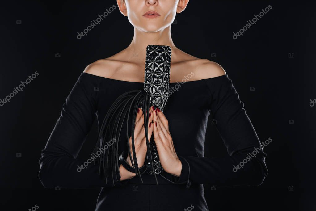 vista parcial de la mujer con las manos en oración sosteniendo látigo