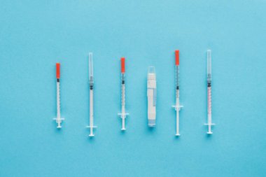 top view of insulin syringes for diabetes on blue background clipart