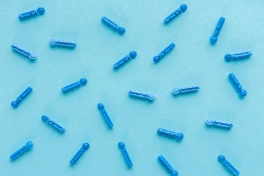 top view of disposable needles in scatter on blue background clipart