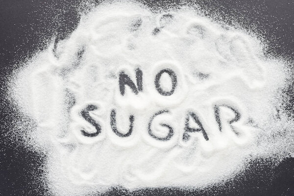 top view of "no sugar" handwritten lettering on grey table