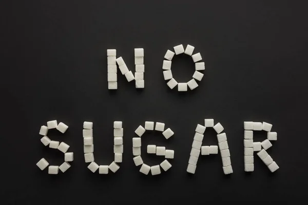 ブラックに分離された砂糖の立方体の 砂糖なし のレタリングの平面図 — ストック写真