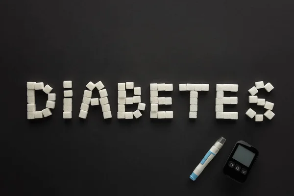 Diabetes Letras Feitas Cubos Açúcar Com Glicosímetro Sobre Fundo Preto — Fotografia de Stock