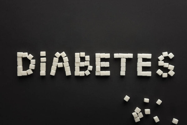 top view of word "diabetes" made of sugar cubes on black