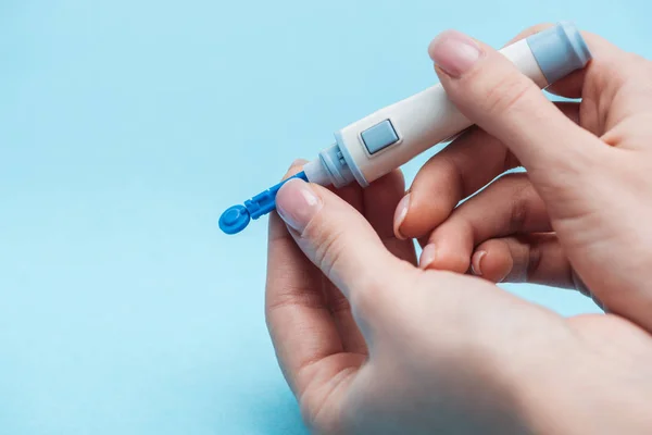 Przycięte Widok Kobiety Badania Poziomu Glukozy Jednorazowej Igły Niebieskim Tle — Darmowe zdjęcie stockowe