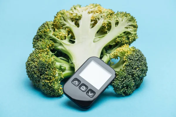 Mavi Arka Plan Üzerinde Brokoli Ile Siyah Şeker Ölçüm — Stok fotoğraf