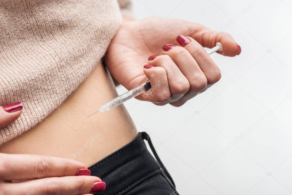 close up view of woman making injection with insulin syringe isolated on white background