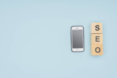 Açık mavi izole harfler ile Smartphone küpleri yakınındaki düz göklere 