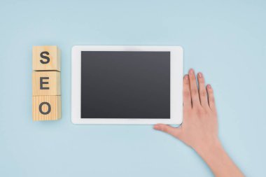 Açık mavi renkli gadget yakınındaki elini tutarak kadın seo Yöneticisi üstten görünüm 