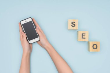 Smartphone üzerinde açık mavi renkli tutan kadın üstten görünüm 