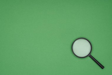 Top view of magnifying glass on green background  clipart