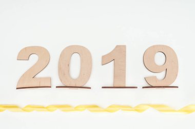 2019 tarihini üstten görünüm üzerinde beyaz izole Sarı kurdele ile ahşap numaralar yapılmış