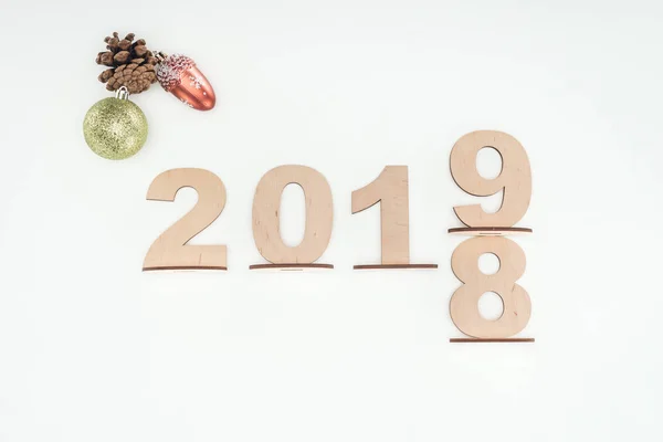 top view of wooden numbers with date symbolizing change from 2018 to 2019 with christmas decorations isolated on white