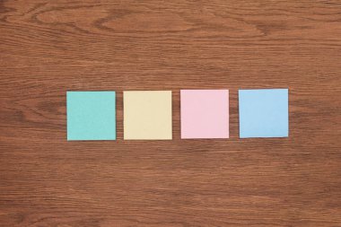 top view of four sticky notes on wooden tabletop clipart