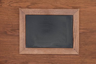 top view of empty chalk board on wooden background clipart