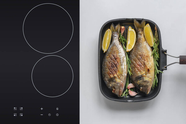 top view of delicious dorado fish with rosemary and lemon on grill 