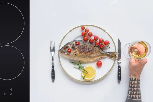 Обрізаний Знімок Людини Тримає Келих Вина Смачну Смажену Рибу Тарілці — Безкоштовне стокове фото