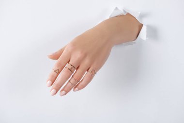 cropped image of woman holding hand with beautiful luxury silver rings through white paper clipart