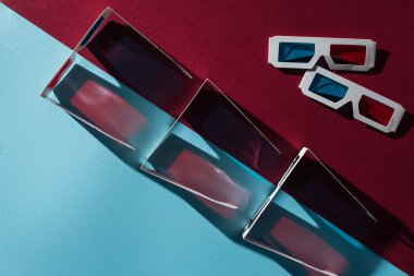 top view of 3d glasses with shadows on blue and bordo background clipart