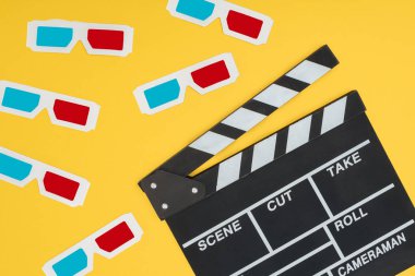 plastic 3d glasses and clapperboard isolated on yellow clipart